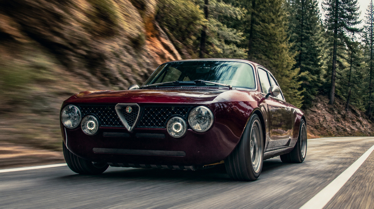 Carro esportivo clássico Alfa Romeo na cor vinho dirigindo em estrada cercada por árvores e pedras.
