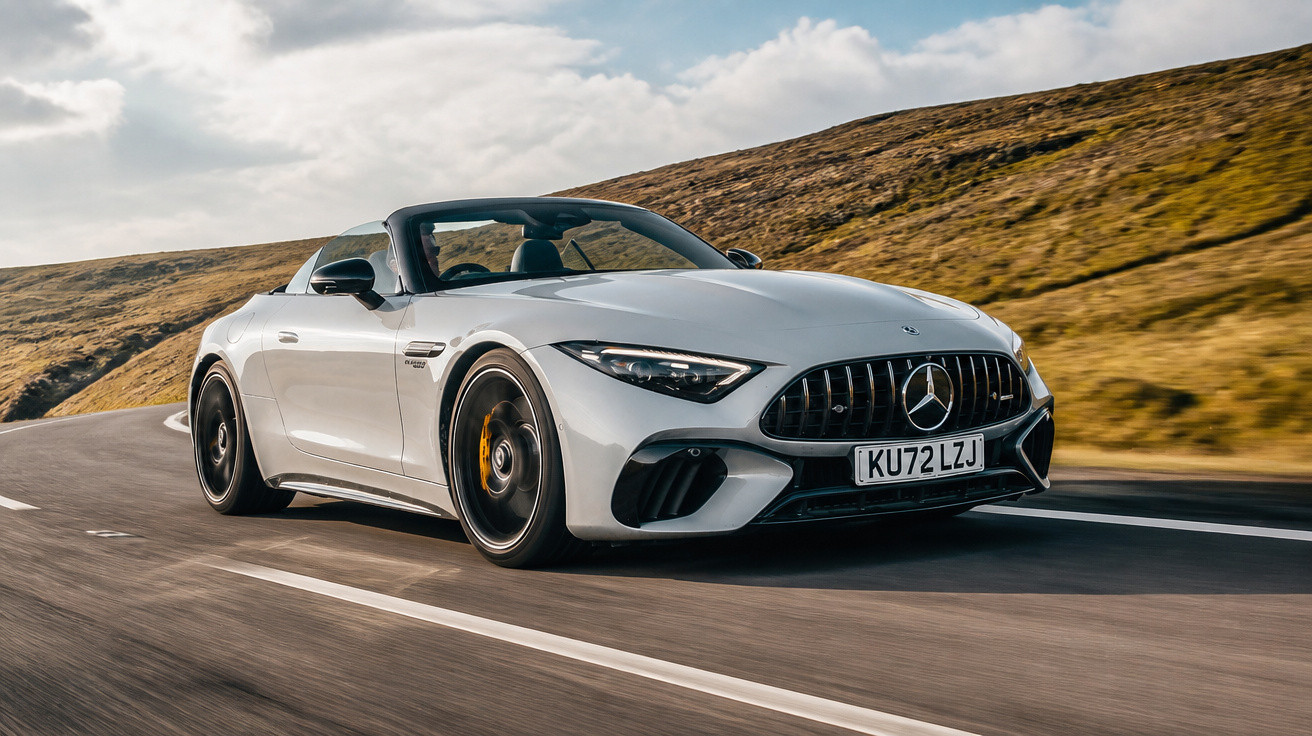 Carro esportivo conversível branco Mercedes-Benz em estrada sinuosa com colinas ao fundo.