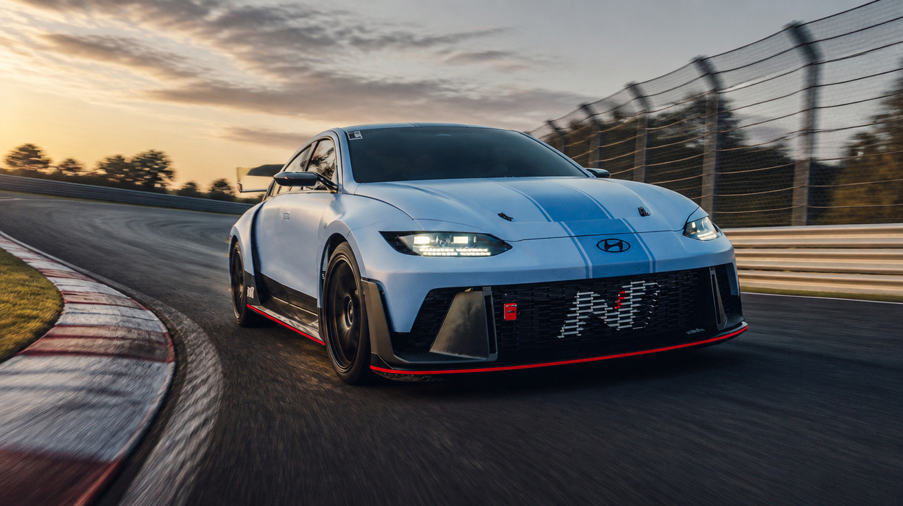 Carro esportivo Hyundai N em pista de corrida ao pôr do sol com céu parcialmente nublado.