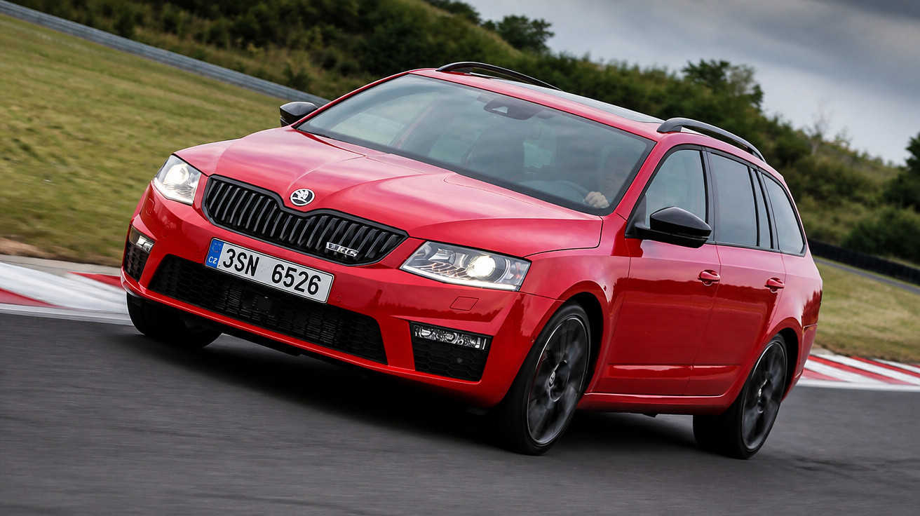 Carro esportivo vermelho Skoda Octavia RS em pista de corrida com céu nublado ao fundo.