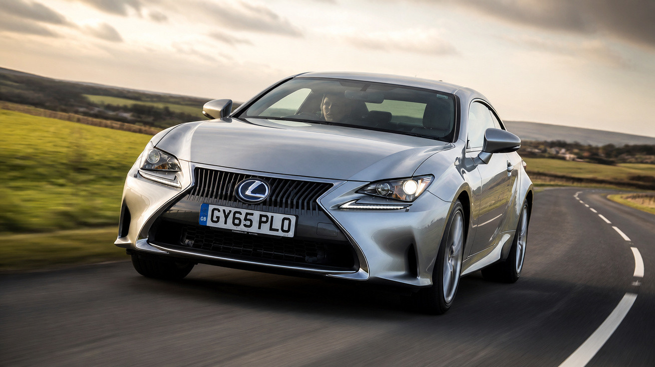 Carro esportivo Lexus prata dirigindo em estrada sinuosa com paisagem ao fundo em dia nublado.