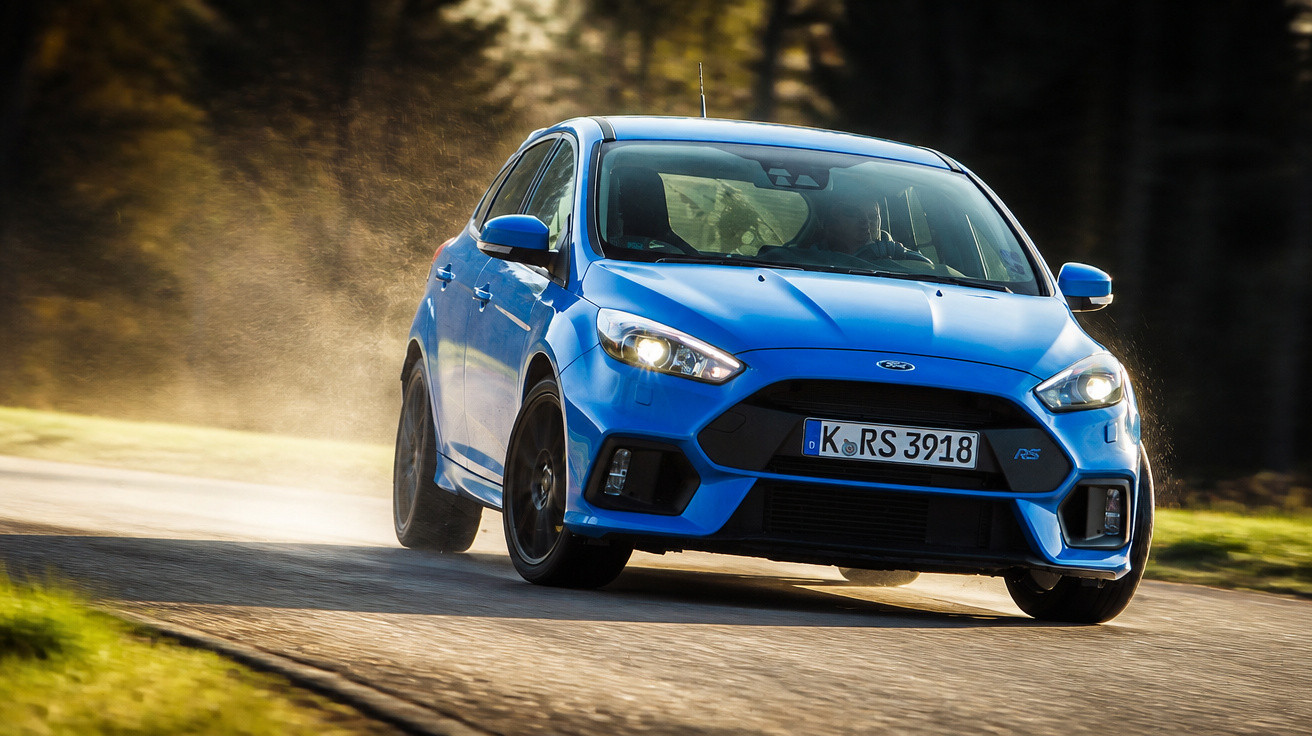 Carro esportivo azul em curva rápida em estrada com fundo desfocado e luz natural.