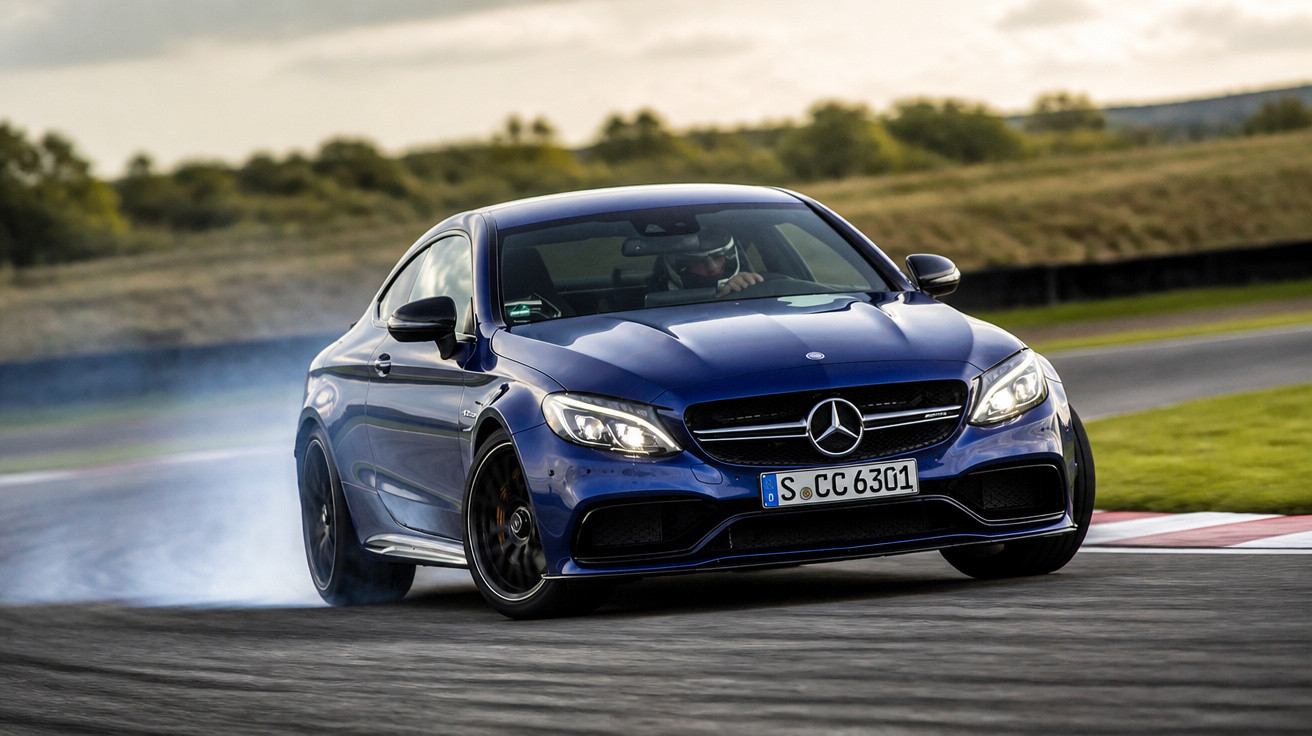 Carro esportivo azul Mercedes-Benz derrapando em pista de corrida com fumaça saindo dos pneus.