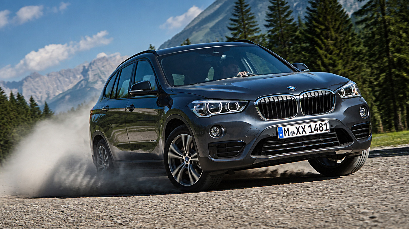Carro BMW cinza escuro em alta velocidade em estrada de terra com árvores e montanhas ao fundo.