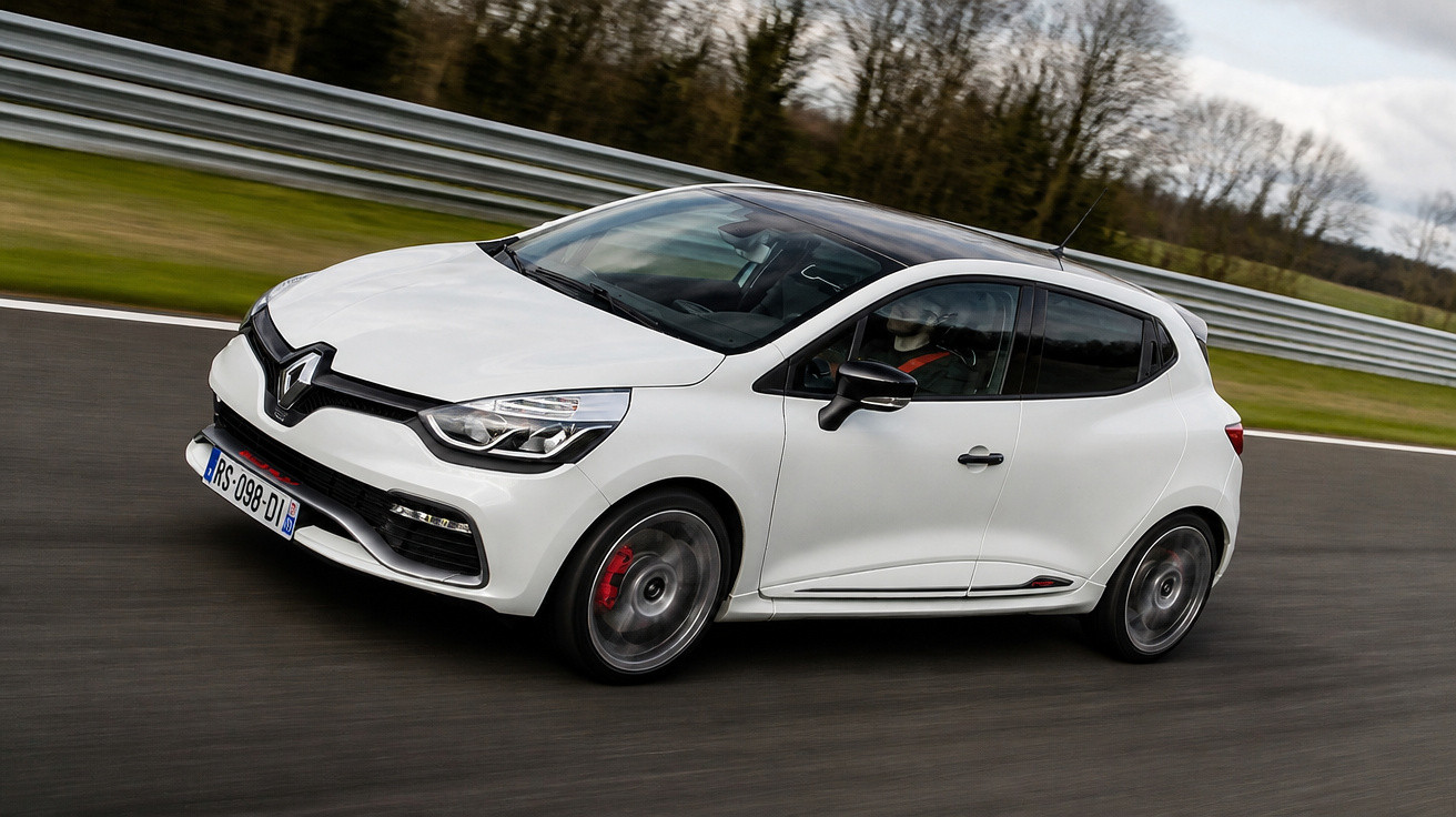 Carro branco da marca Renault em alta velocidade em pista de corrida com grades metálicas ao fundo.