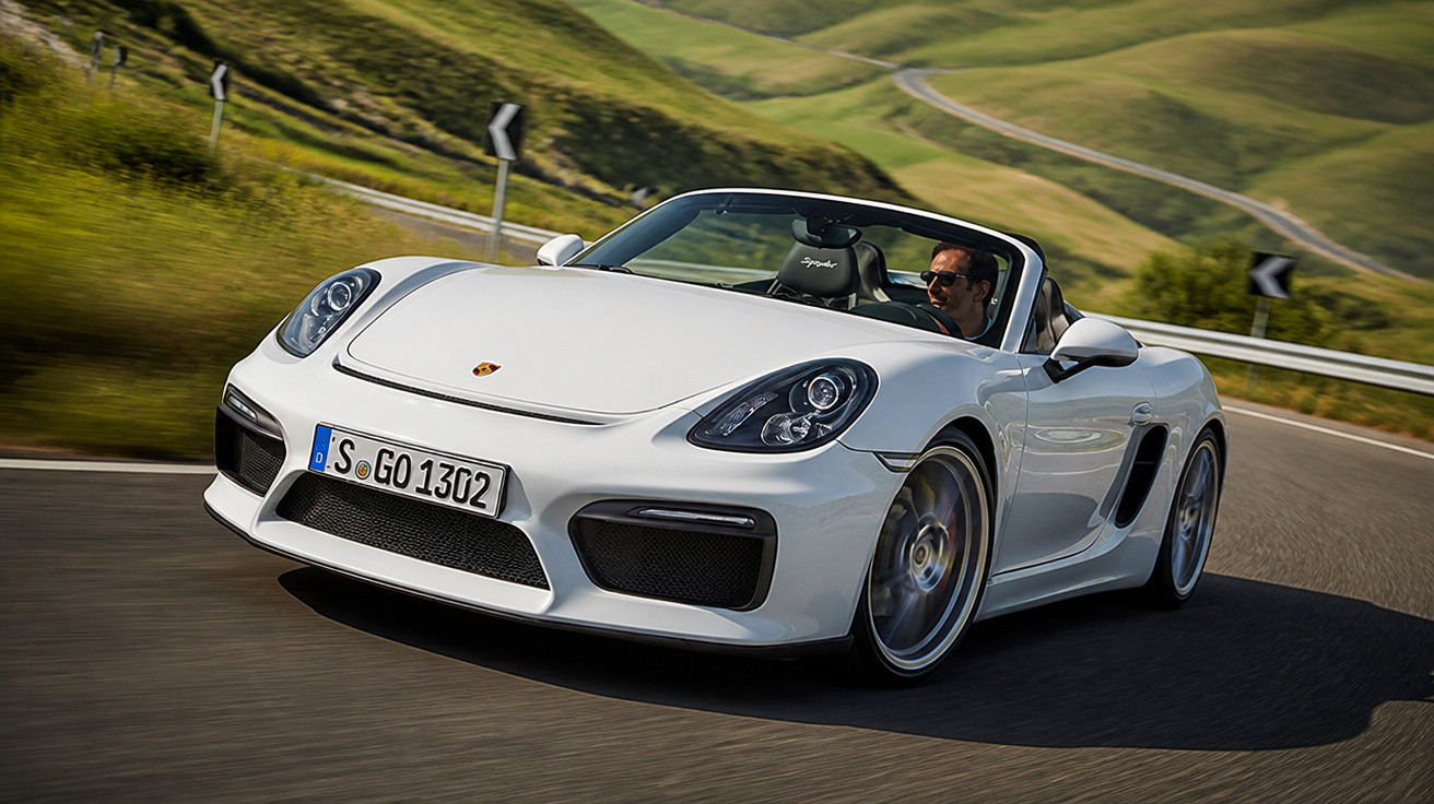 Porsche conversível branco em curva de estrada sinuosa com motorista usando óculos escuros.