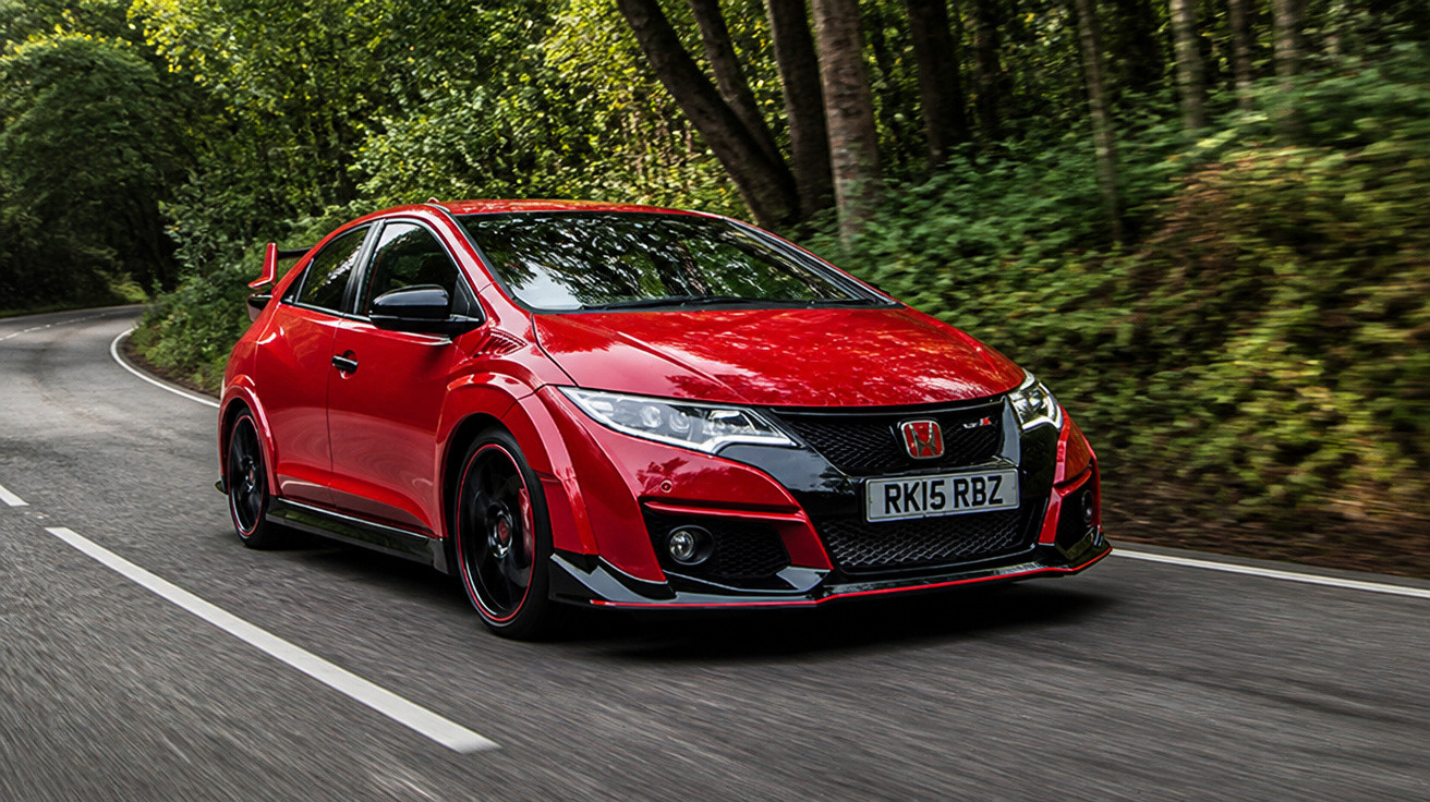 Carro esportivo vermelho Honda Civic Type R trafegando em estrada cercada por árvores.