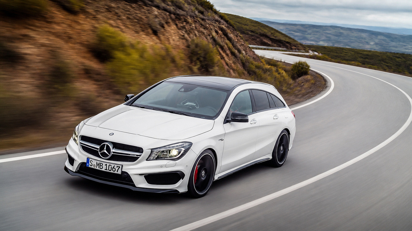 Carro branco Mercedes-Benz modelo CLA em estrada sinuosa próxima a morro rochoso em dia claro.