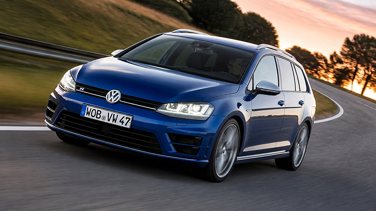 Carro Volkswagen azul dirigindo em estrada curva ao pôr do sol em área rural.