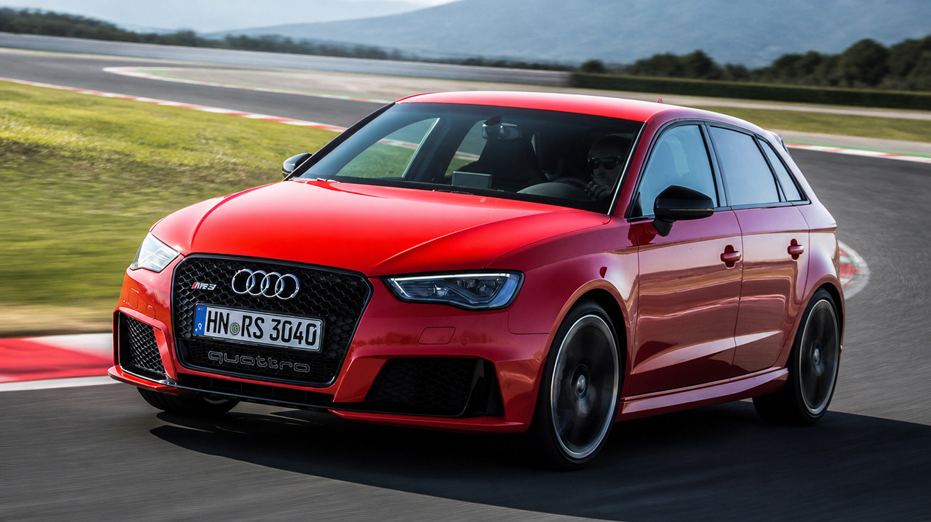 Carro Audi RS3 vermelho em alta velocidade contornando curva de pista de corrida.