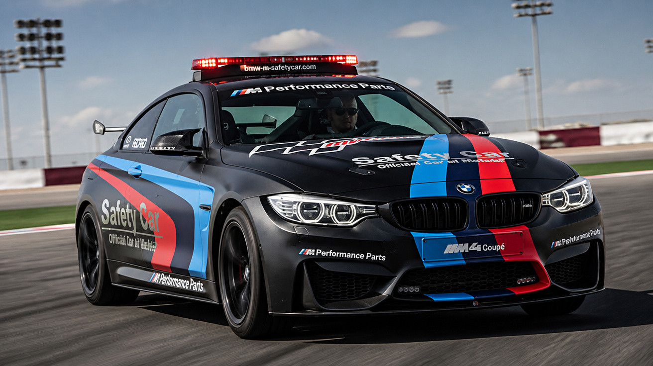 Carro de segurança BMW M4 com luzes vermelhas em pista de corrida ao ar livre.