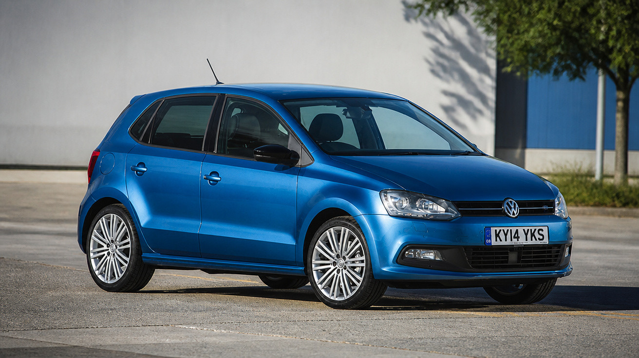 Carro Volkswagen Polo azul estacionado em área externa iluminada pelo sol.